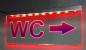 Preview: LED WC-Schild schmal  "WC + Pfeil n. rechts (oder auf Wunsch n. links)" (Klosett Örtchen Toilette) Toilettenschild Hinweisschild Wegweiser Leuchtschild